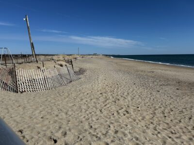 a beach with a fence and a structure on it (MyCoast AI)