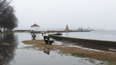 a body of water with a dock and a building in the distance (MyCoast AI)