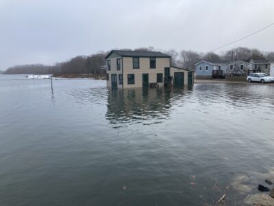 a flooded area with houses and a car parked in the water (MyCoast AI)