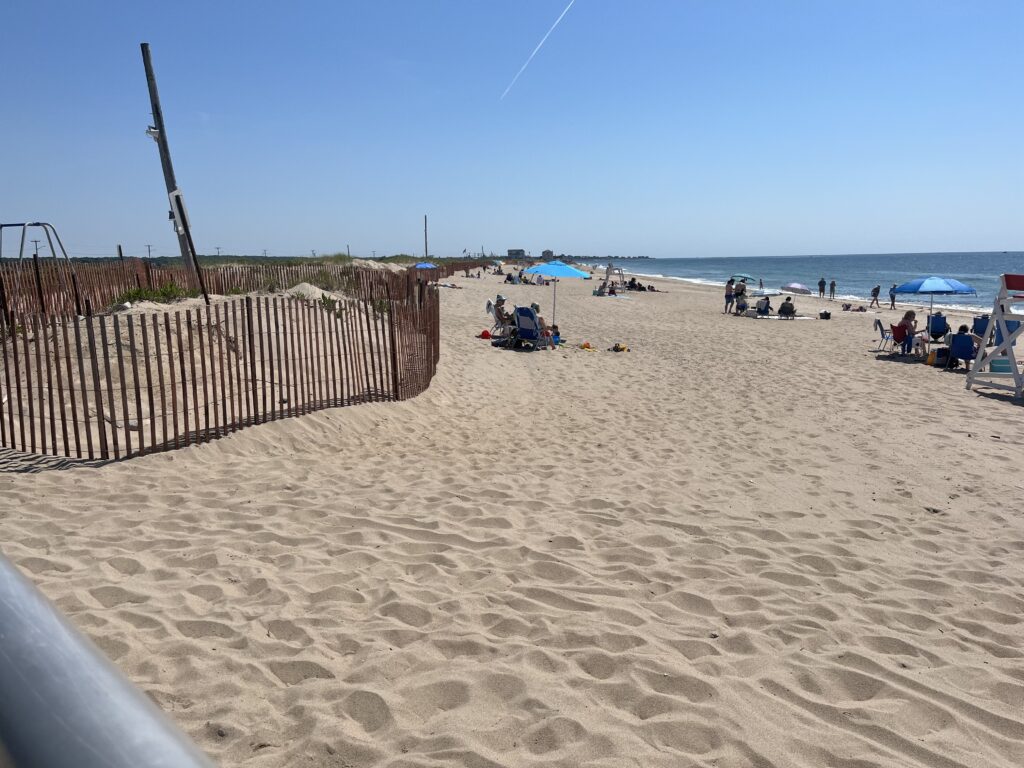 a sandy beach with people and umbrellas (MyCoast AI)