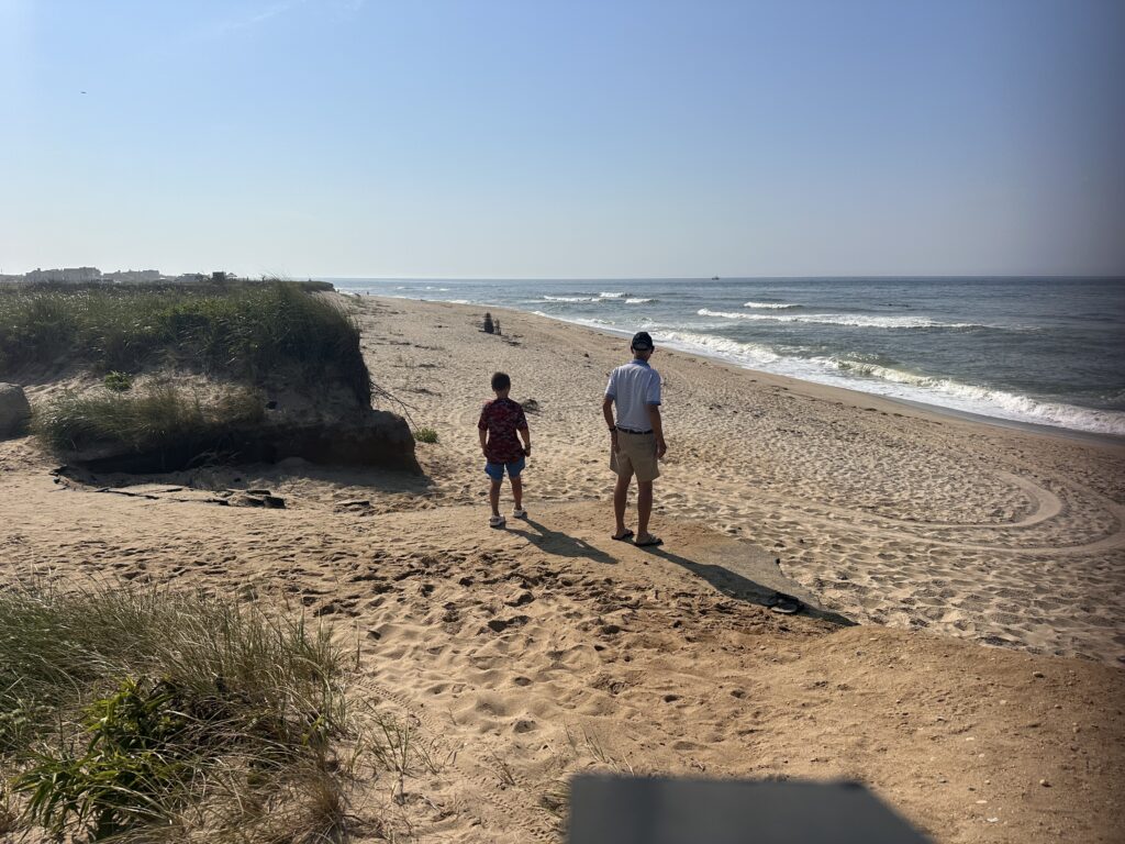 a man and a boy walking on a beach (MyCoast AI)
