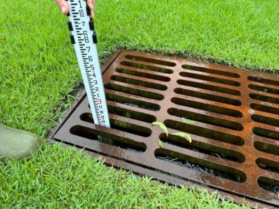 a hand holding a knife over a wood box on grass (MyCoast AI)