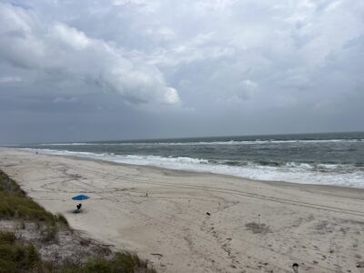 a beach with a blue umbrella (MyCoast AI)