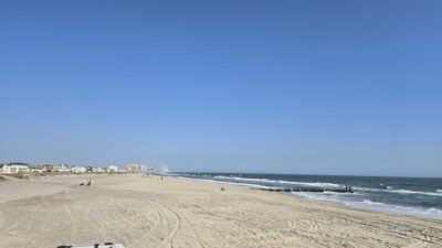 a sandy beach with people and buildings (MyCoast AI)