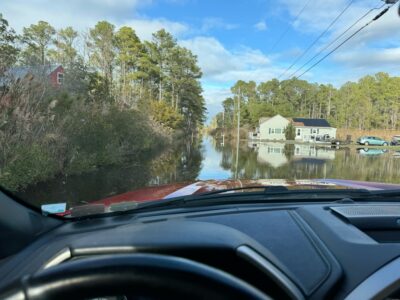 a car driving on a road next to a body of water (MyCoast AI)