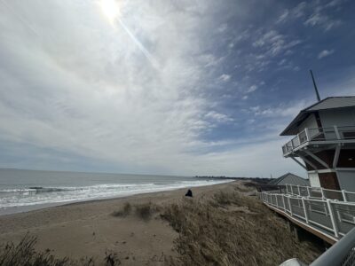 a beach with a building and a body of water in the background (MyCoast AI)