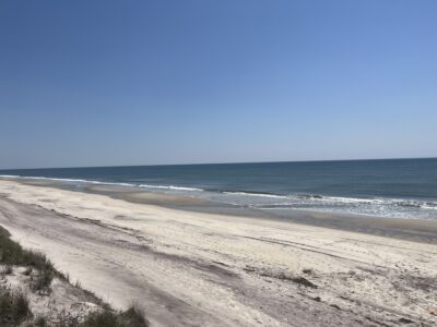 a sandy beach with waves crashing on it (MyCoast AI)