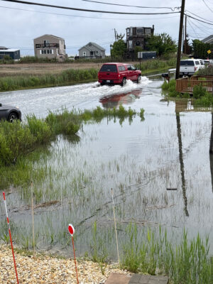 a flooded street with cars and houses (MyCoast AI)