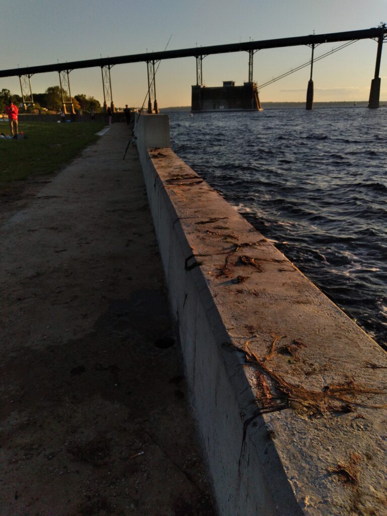 a concrete walkway next to a body of water (MyCoast AI)