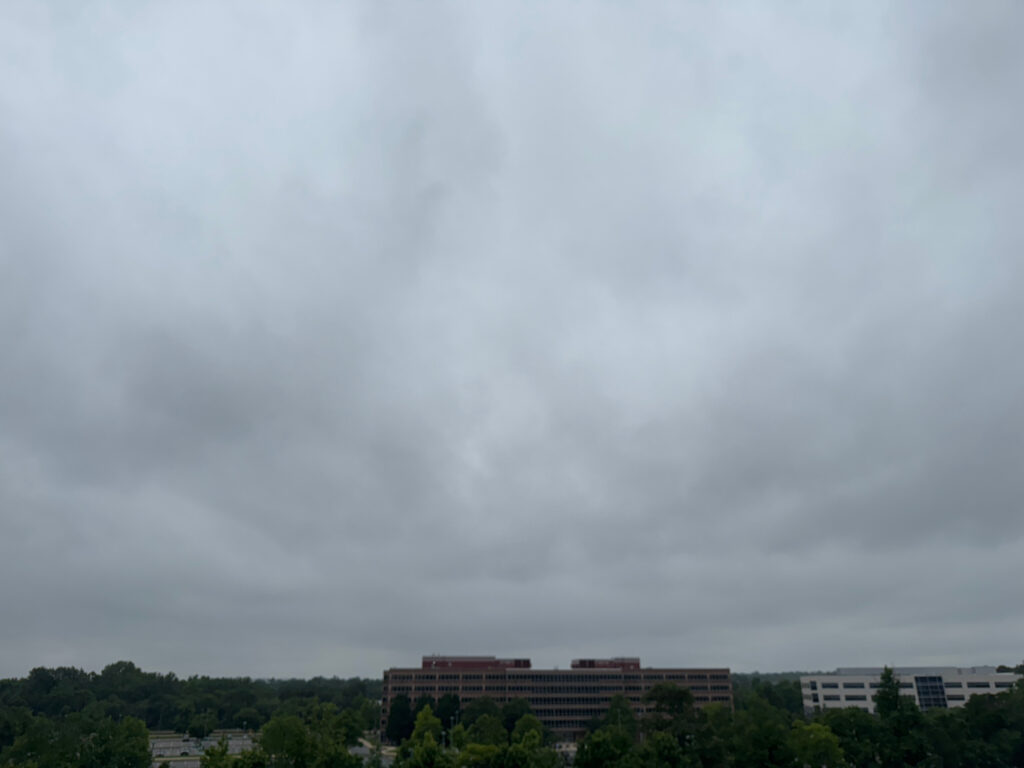 a cloudy sky over trees and buildings (MyCoast AI)