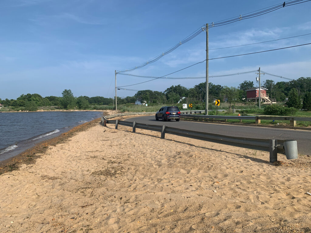 a car driving on a road next to a body of water (MyCoast AI)