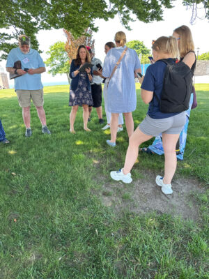 a group of people standing in a grassy area (MyCoast AI)