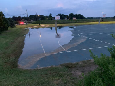 a flooded road with a car driving by (MyCoast AI)