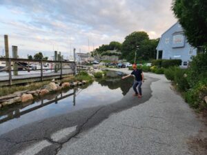 a man standing in a puddle of water in a neighborhood (MyCoast AI)