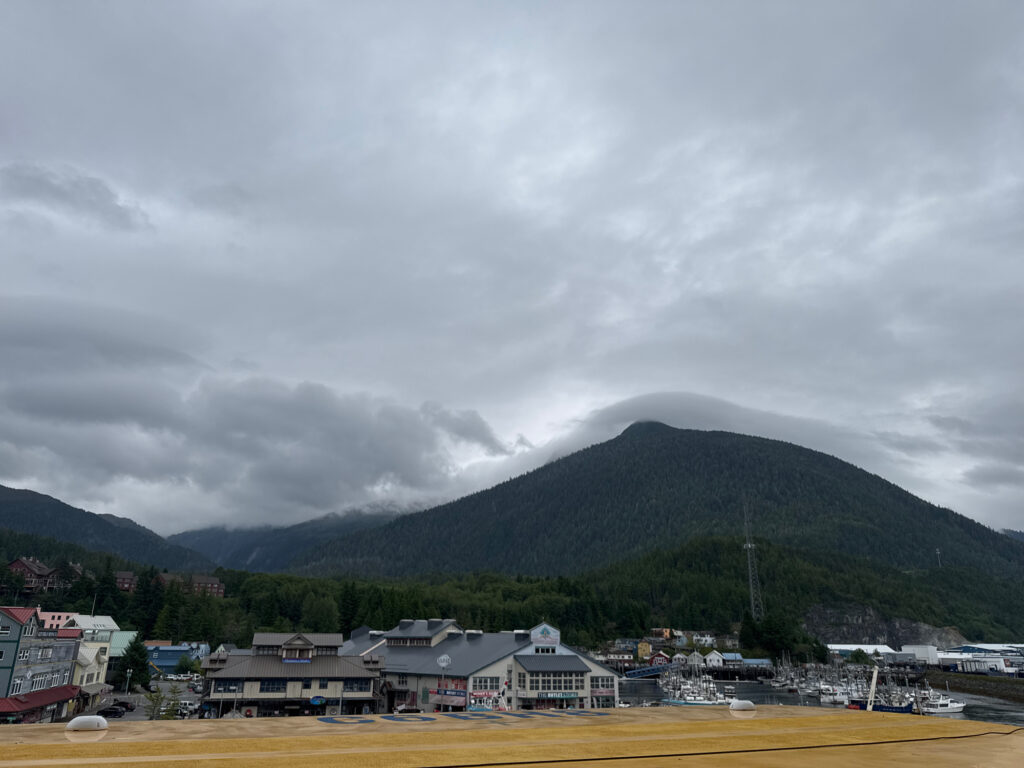a group of buildings by a body of water with mountains in the background (MyCoast AI)