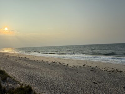 a beach with waves and the sun setting (MyCoast AI)