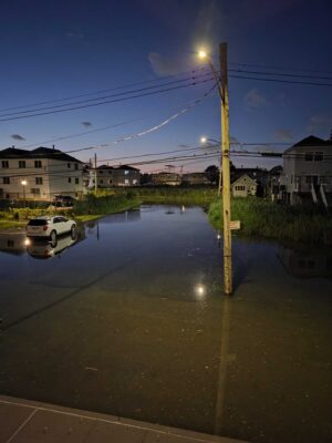 a flooded street with a car parked on the side (MyCoast AI)