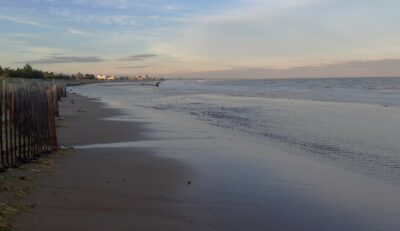 a beach with a fence and water (MyCoast AI)