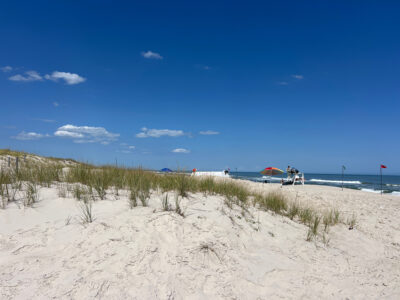 a beach with a few people and a couple of boats (MyCoast AI)