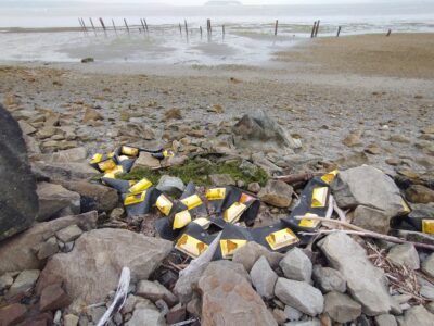 a rocky beach with a motorbike and a bike parked on the sand (MyCoast AI)