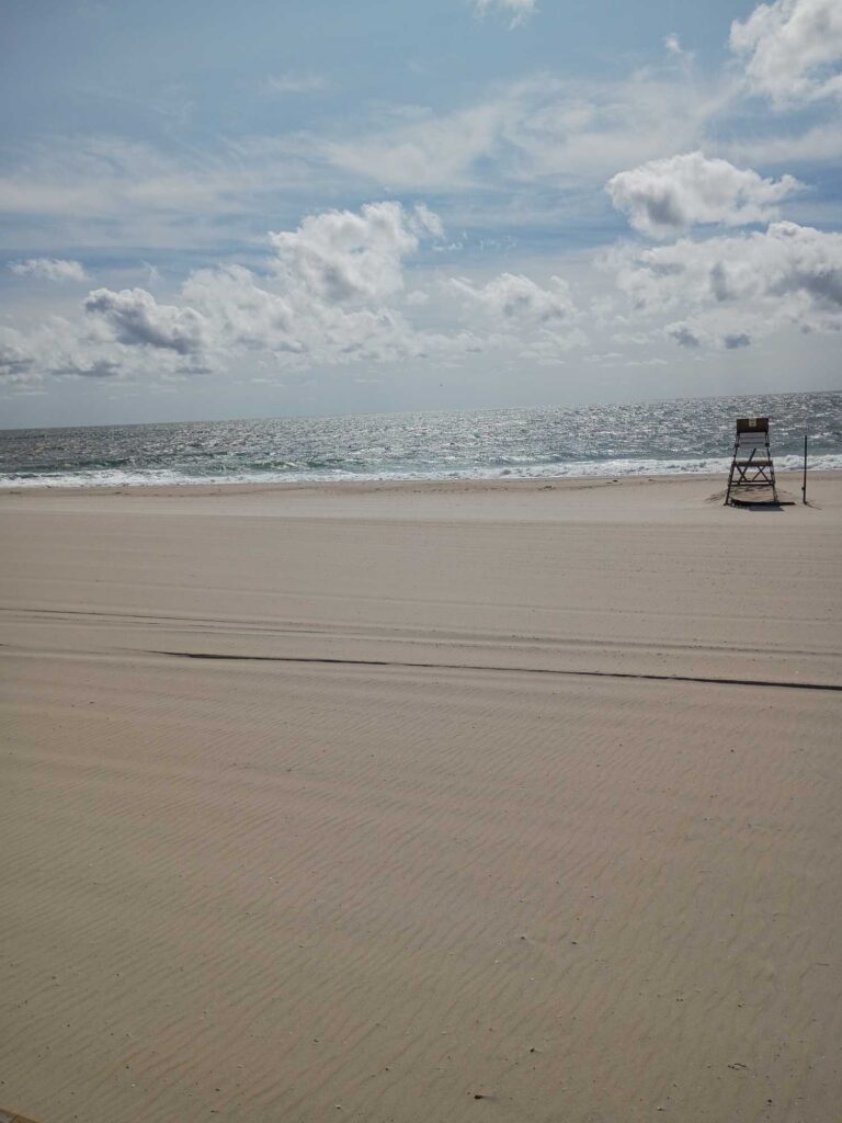 a sandy beach with a chair and a chair on it (MyCoast AI)