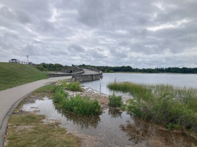 a body of water with a bridge and grass and a road (MyCoast AI)