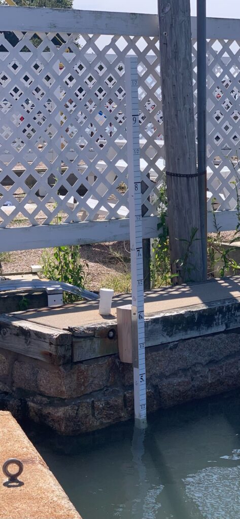 a metal fence with a white bucket and a white bucket on a wooden platform by a pool (MyCoast AI)