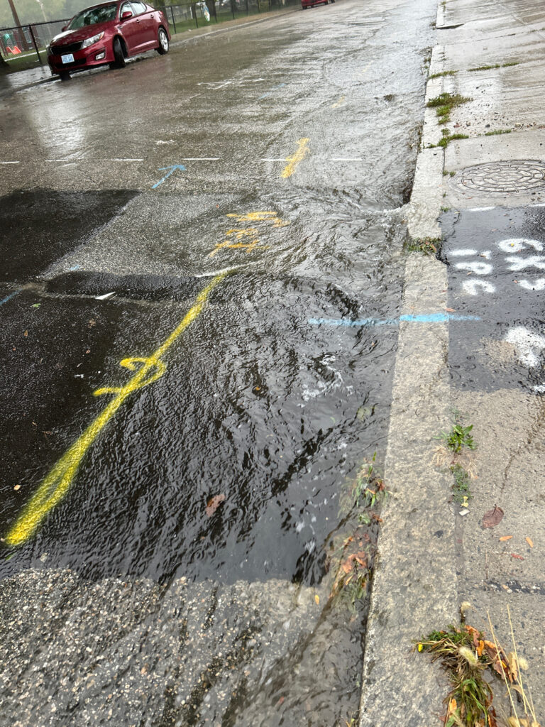 a wet road with a red car (MyCoast AI)