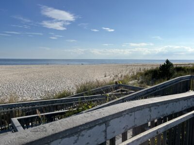 a rail road going through a rocky area with a beach and blue sky (MyCoast AI)