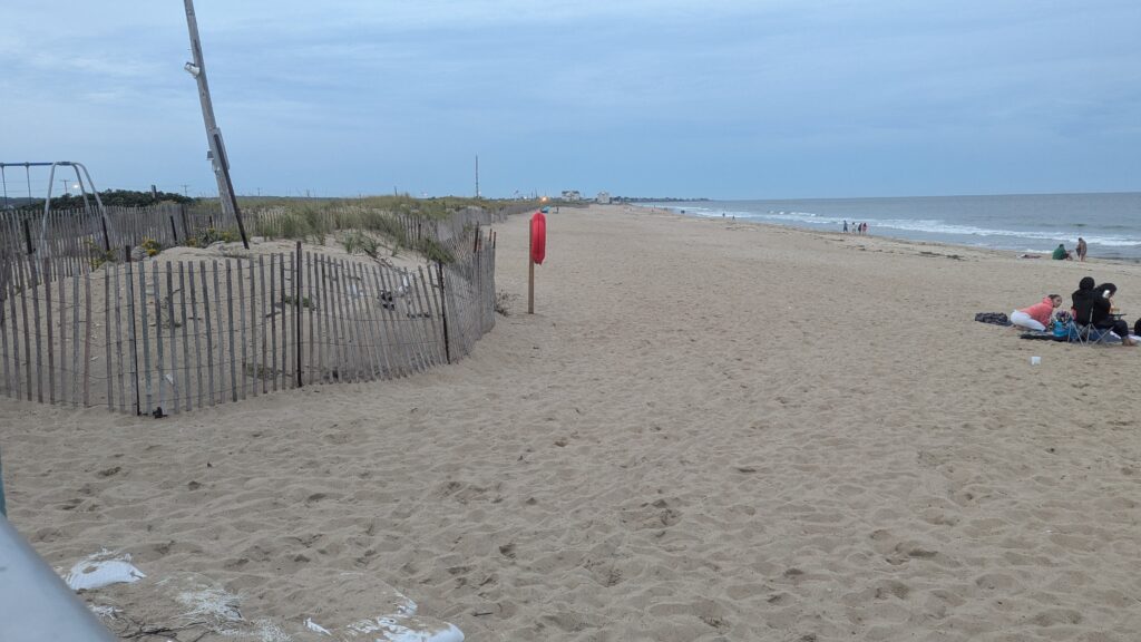 a beach with a fence and people (MyCoast AI)