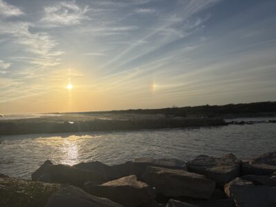 a body of water with rocks and a sunset (MyCoast AI)