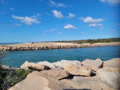 a body of water with rocks and a beach in the background (MyCoast AI)