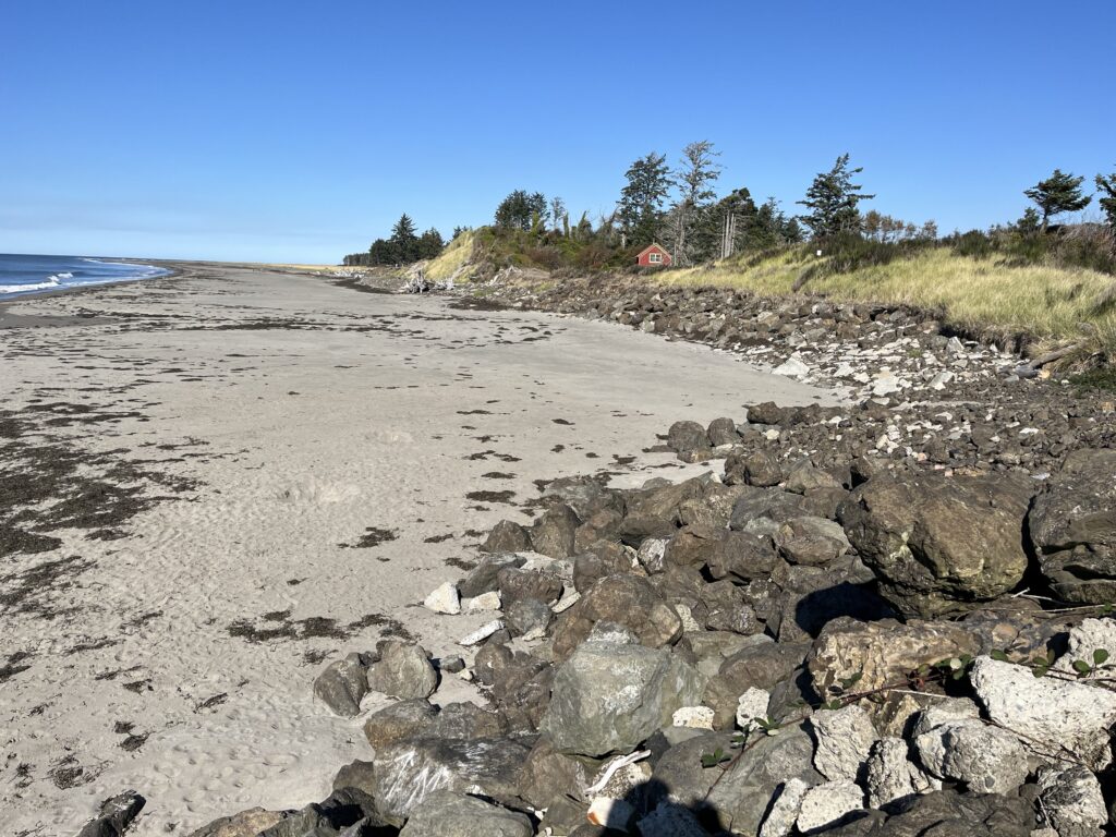 a rocky beach with a house in the distance (MyCoast AI)