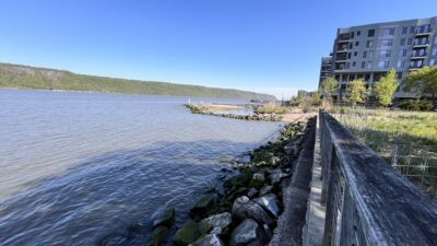 a body of water with rocks and buildings in the background (MyCoast AI)