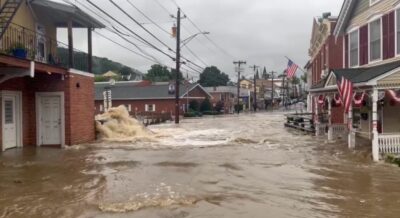 a flooded street with buildings and a flag on the side (MyCoast AI)